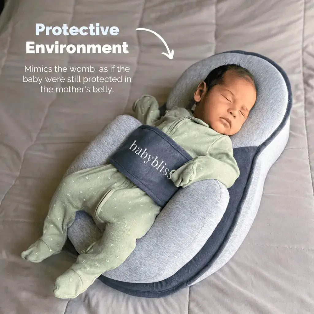 Baby sleeping in a protective environment resembling the womb, with 'babybliss' branding.